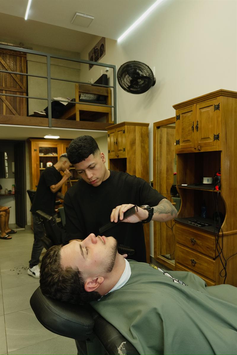 Guilherme atendendo um cliente na Barbearia 08